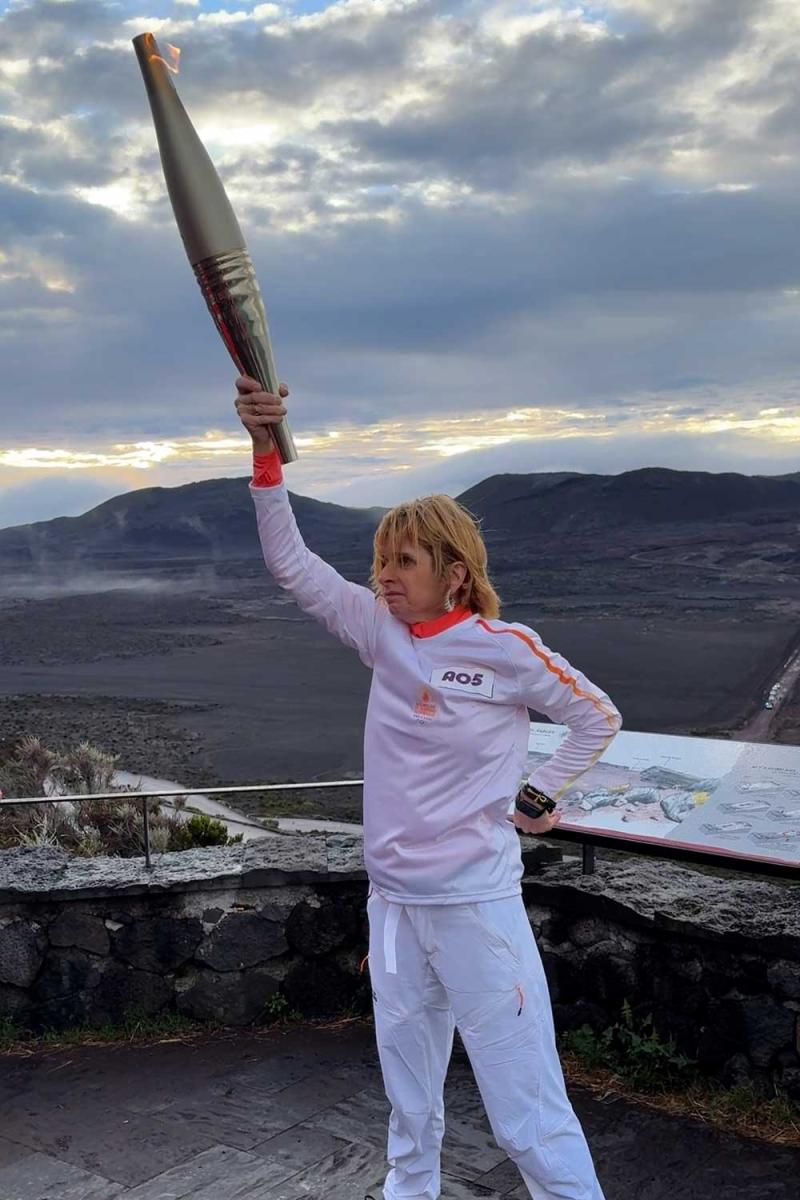 La porteuse hisse la flamme dos aux paysages lunaires caractéristiques de la Plaine des Sables